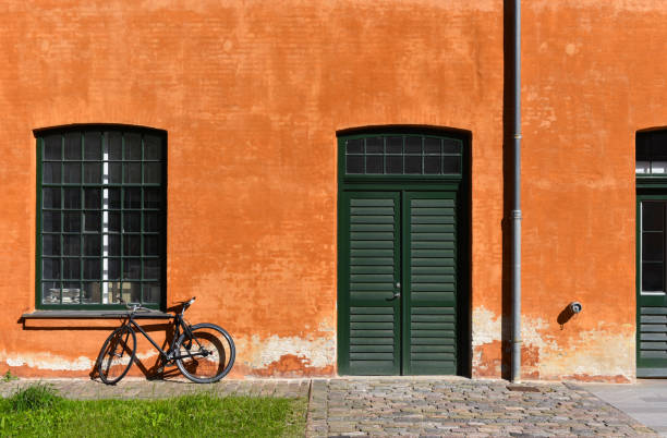 Bicycle in front of an orange old house facade of Holmen Nord harbour of Copenhagen, Denmark