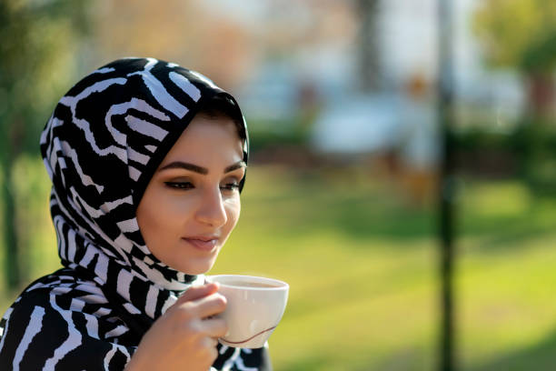 istock Young beautiful muslim female holding coffee cup 1195020015