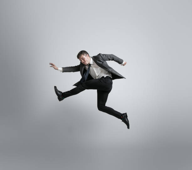 istock Caucasian man in office clothes running isolated on grey studio background 1195021342