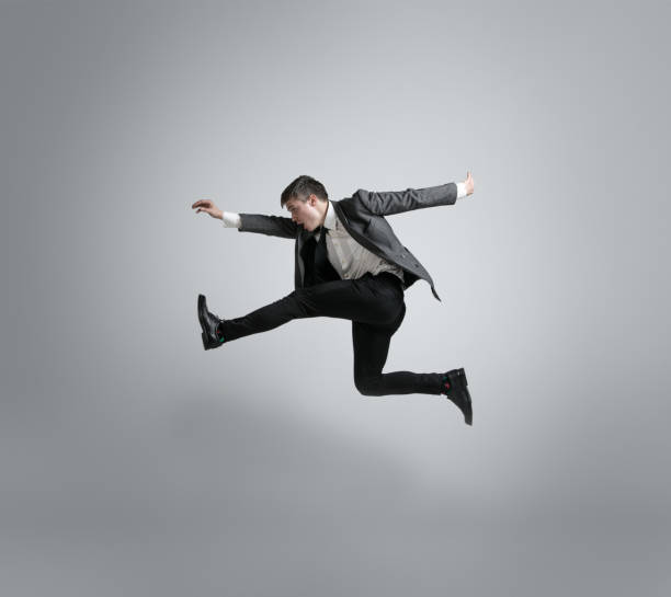 istock Caucasian man in office clothes running isolated on grey studio background 1195021360