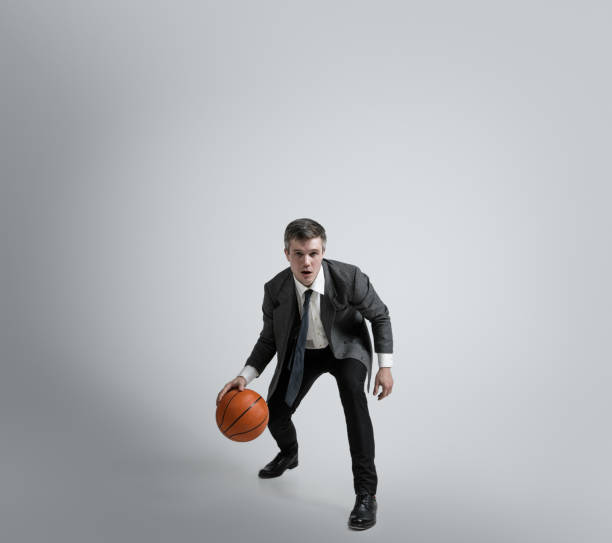 istock Caucasian man in office clothes training isolated on grey studio background 1195021383