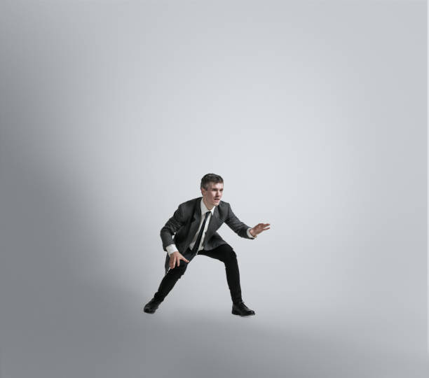 istock Caucasian man in office clothes training isolated on grey studio background 1195021439