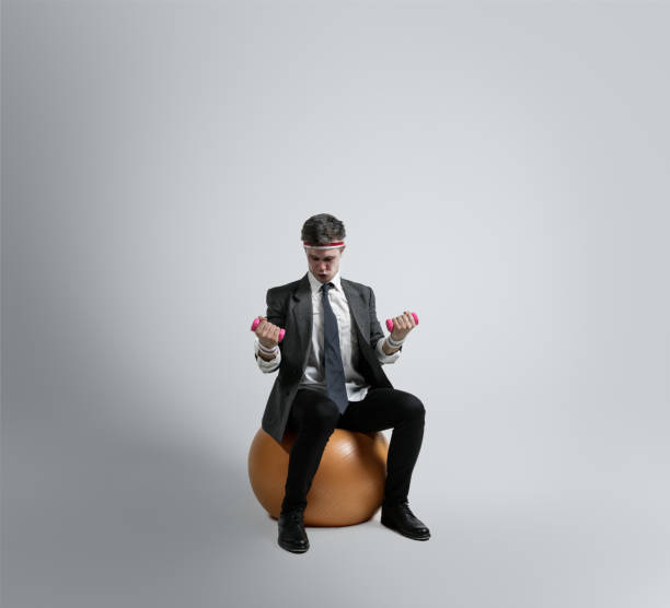 istock Caucasian man in office clothes training isolated on grey studio background 1195021461