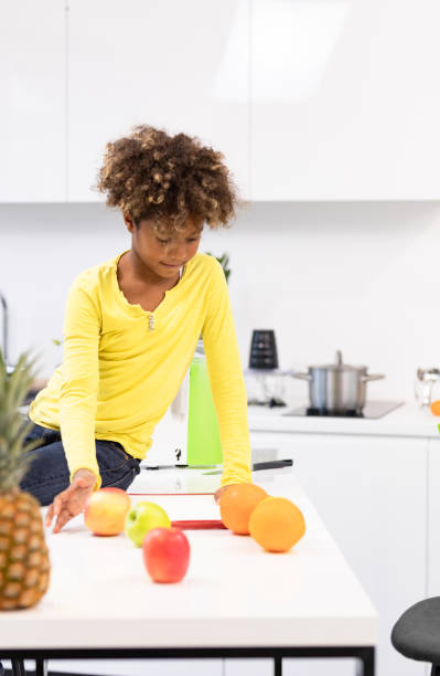 istock beautiful afro child playing in a white kitchen 1195022335