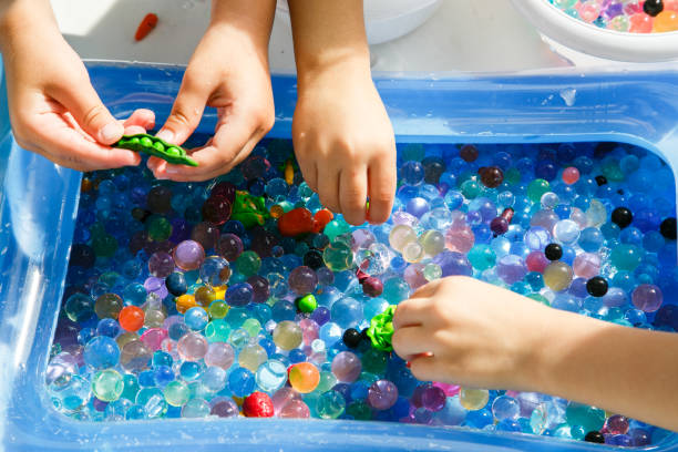 istock child playing with colored glass ball, playing game with colored balls, 1195027075