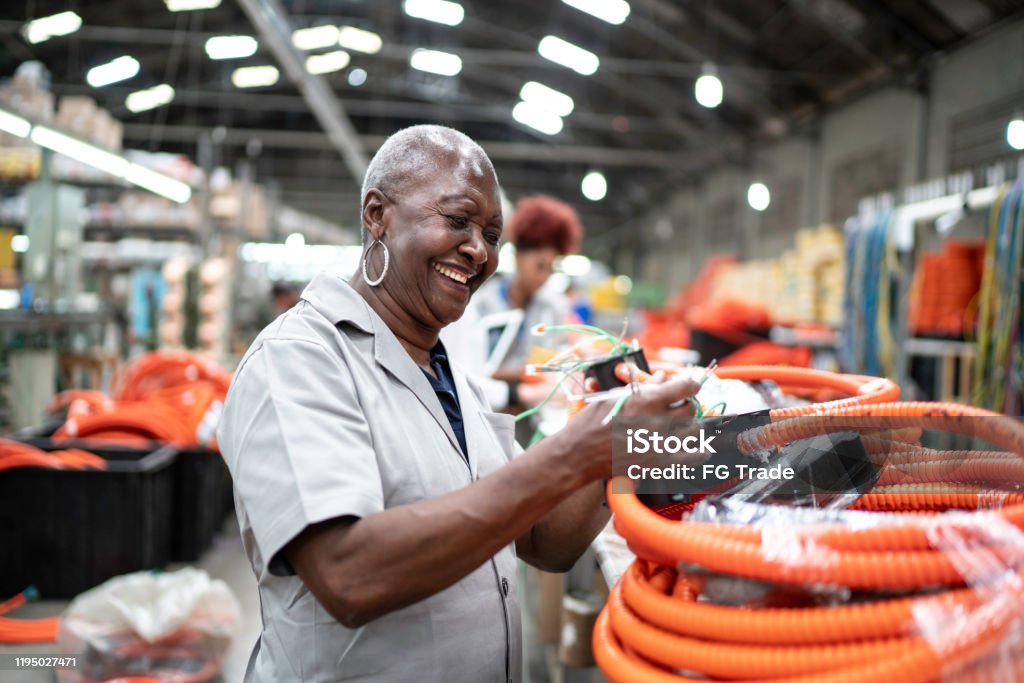 Senior woman working in a factory Manufacturing Occupation Stock Photo