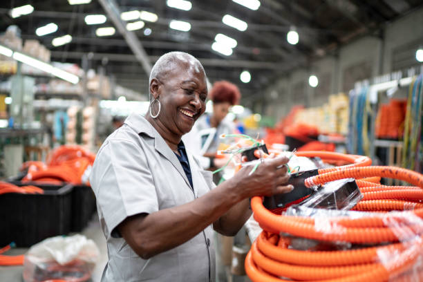 Senior woman working in a factory Senior woman working in a factory production line worker stock pictures, royalty-free photos & images