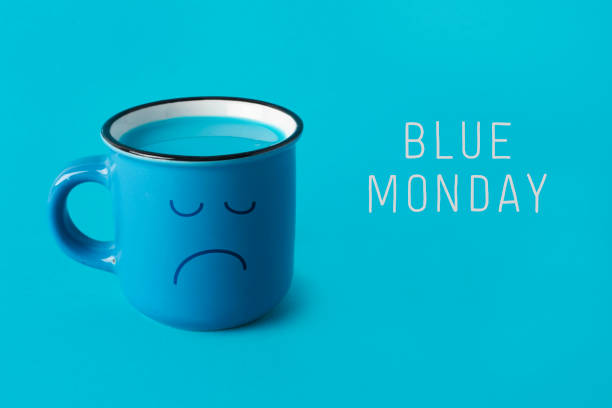blue mug with sad face and text blue monday closeup of a blue mug, with a sad face drawn in it, and the text blue monday on a blue background january in spanish stock pictures, royalty-free photos & images