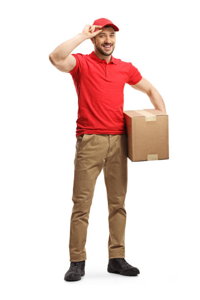 istock Delivery man with a box smiling and holding his cap 1195028628