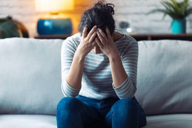 istock Depressed young woman thinking about her problems while sitting on the sofa at home. 1195029999