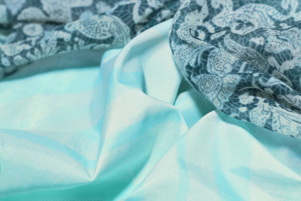 istock Light green and multi-colored satin or silk fabric with large folds. The material is flexible and light in design, can be used as wallpapers or backgrounds in advertising. Abstract background, blurred image. 1195030142