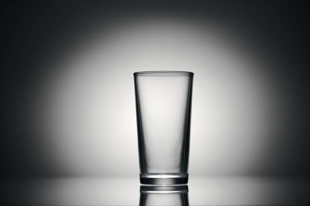 istock one empty glass for water on a dark background 1195034369