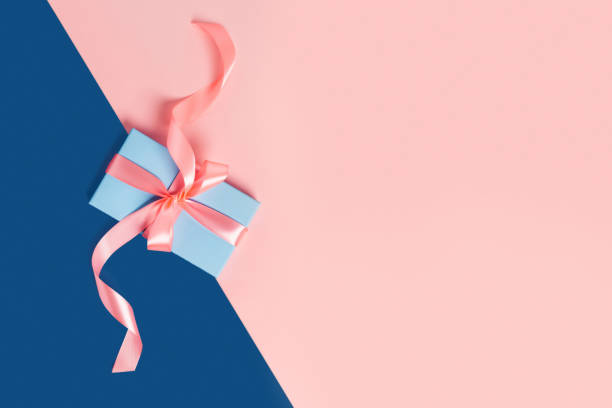 istock Holiday card. Blue box with a pink bow on two-toned background. 1195034903