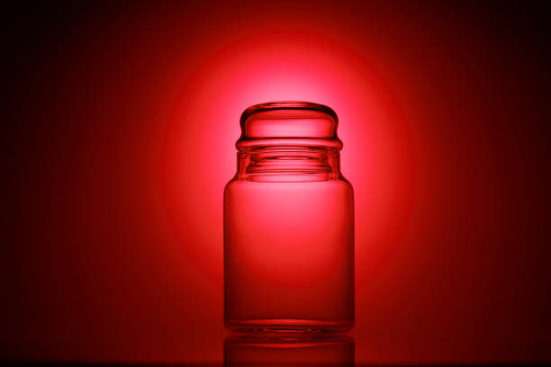 istock Empty glass jar on a red and black background 1195036292