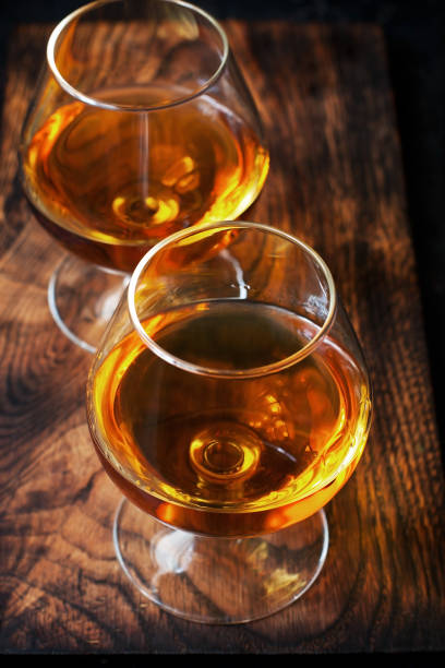 istock Two glasses of brandy or cognac on  dark table 1195036464
