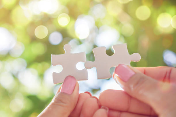 istock hand holding jigsaw over nature sunlight background, business teamwork,unity concept 1195037200