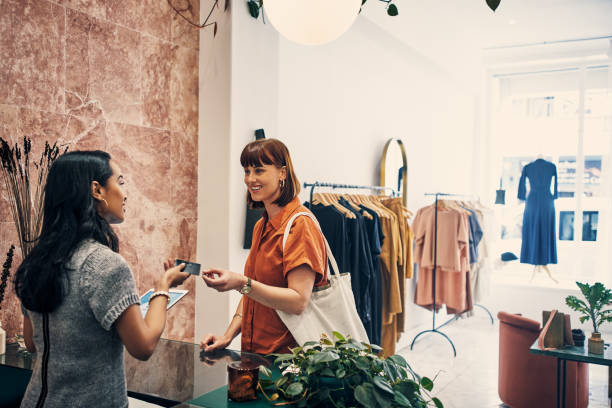 Can I email your receipt to you? Shot of a customer paying with a credit card in a clothing store clothing store credit card stock pictures, royalty-free photos & images