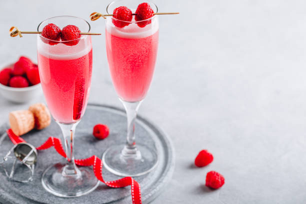 cocktail rose au champagne ou prosecco et framboises fraîches pour la saint-valentin. - champagne cocktail raspberry pink photos et images de collection