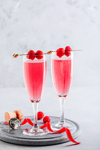 Pink cocktail with champagne or prosecco and fresh raspberries for St. Valentine's day.