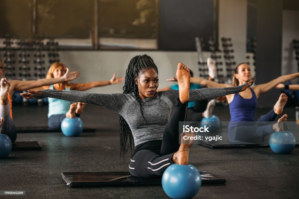 Get Your Body In Balance Group of women working balance exercise in the gym. Exercising Stock Photo