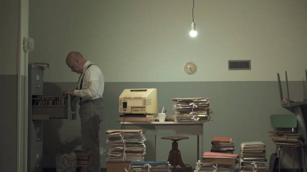 istock Businessman searching for files in a messy office 1195045772