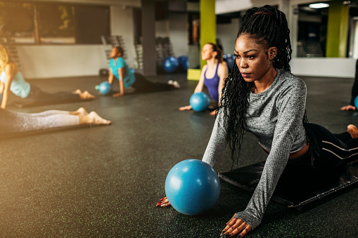 Focused young woman exercising on pilates class.