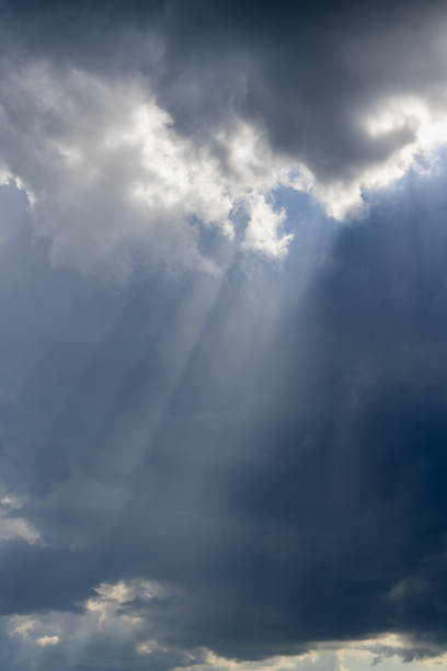 istock Beautiful vertical cloudscape with sunrays shining through the dark clouds 1195051388