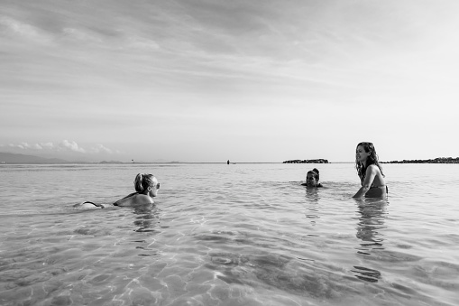 Black and white photograph of young women from three different countries, backpacking in Southeast Asia, enjoying the beach on Mamutik Island in Kota Kinabalu, Sabah, Malaysia.
