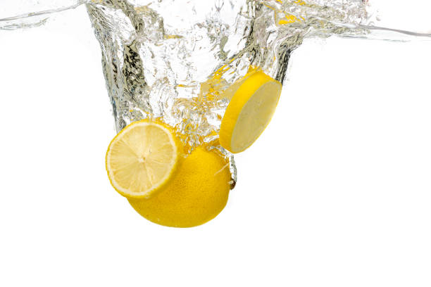 istock whole lemon, half and sliced slices falls under water 1195054559