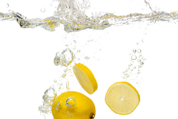 istock whole lemon, half and sliced slices falls under water 1195054634