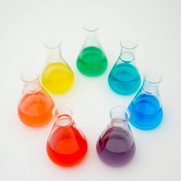 istock Scientific laboratory glass erlenmeyer flask filled with colorful liquid forming rainbow on white background. 1195055155