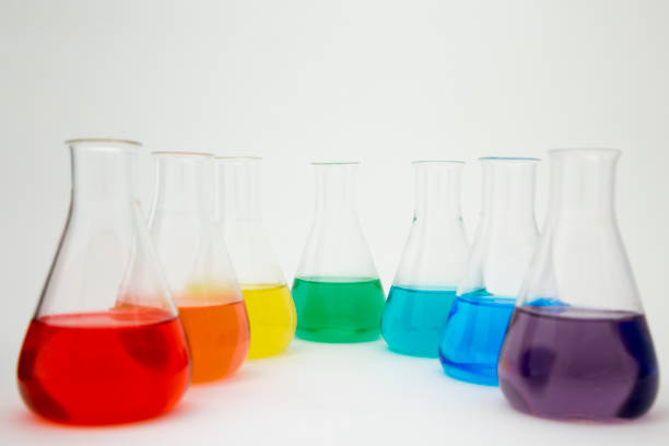 istock Scientific laboratory glass erlenmeyer flask filled with colorful liquid forming rainbow on white background. 1195055238