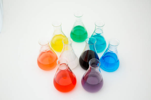 istock Scientific laboratory glass erlenmeyer flask filled with colorful liquid forming rainbow on white background. 1195055923