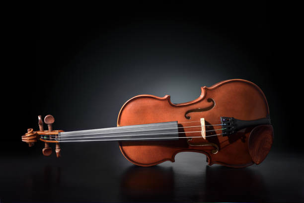 istock Violin reflected on wooden table and black gradient background 1195057412