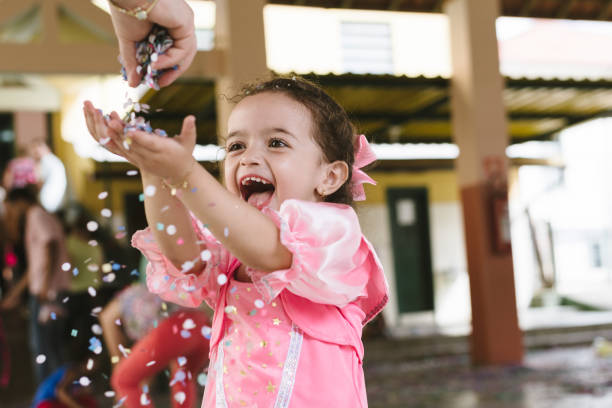 Pretty girl blowing confetti Child at school carnival in Brazil carnival children stock pictures, royalty-free photos & images