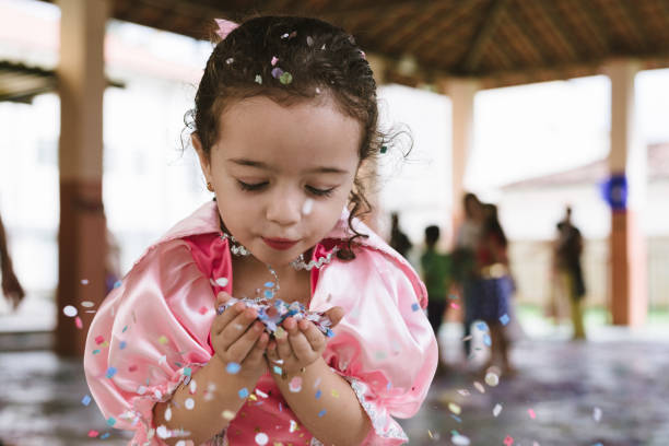 little girl playing dress up with a pink feather boa