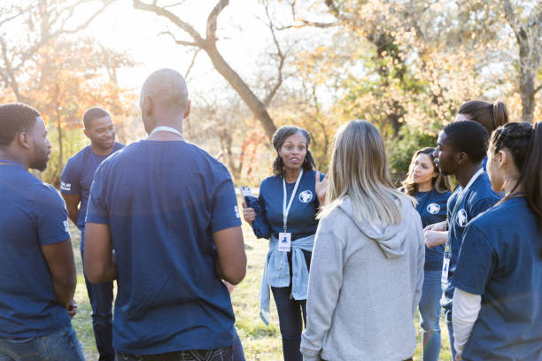 Diverse group of volunteers stand in circle for instructions