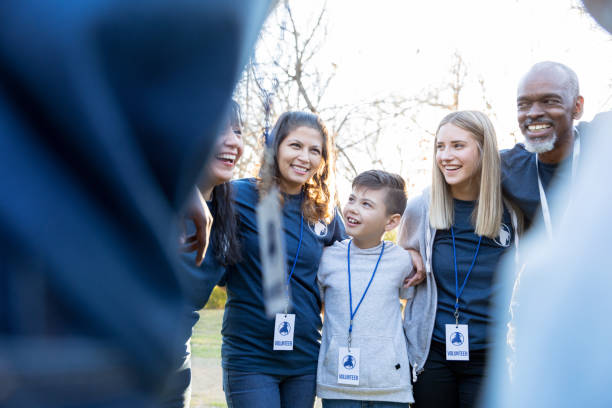 istock Diverse volunteers stand in circle with arms around each other 1195063243