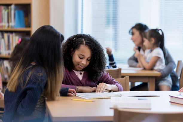 istock Two middle school girls study for test together 1195063438