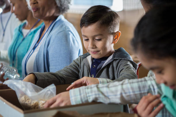 istock Elementary age boy enjoys volunteering during food drive 1195063569