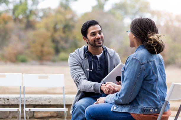 istock Volunteer doctor greets female patient 1195063929