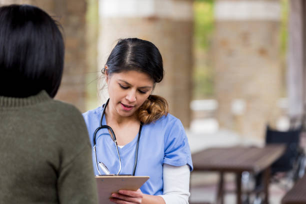 istock Volunteer doctor examines patient's medical chart 1195063961