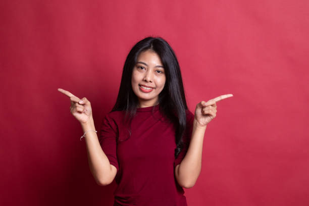 istock Young Asian woman point to left and right. 1195065940