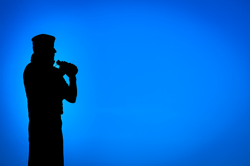 Soldado en silueta sosteniendo binoculares. photo