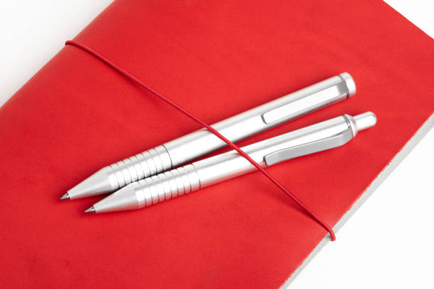 istock Red Leather Journal Cover With Two Ballpoint Pens 1195069568