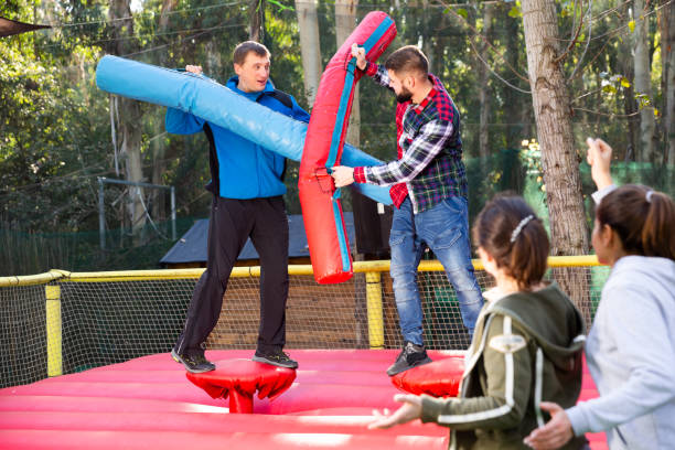istock Men having funny wrestling by inflatable logs 1195069976