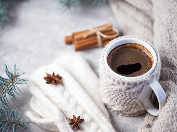 istock Knitted espresso coffee mug winter hot drink on table with homemade knitted wool white mittens and scarf 1195073761