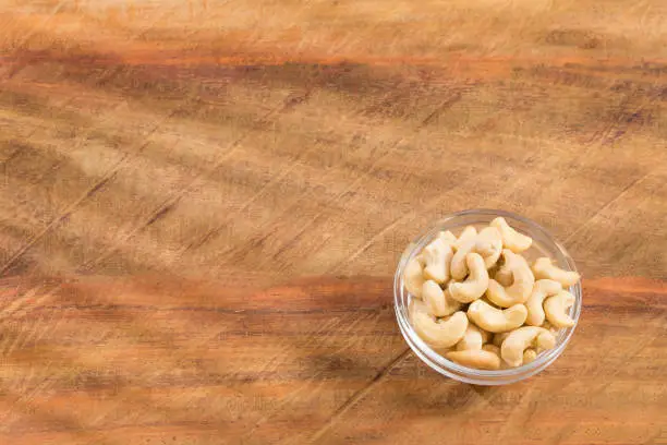 Salted roasted cashews - wooden background. Anacardium occidentale