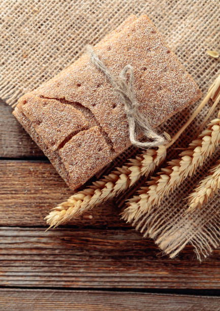 istock Rye crackers and ears on a old wooden table. 1195075995