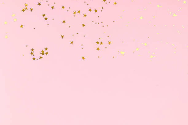 istock Golden stars glitter confetti on pink background. Festive backdrop. 1195079483